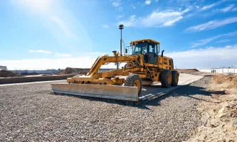 Laser gravel grader on pad